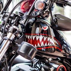 the front end of a motorcycle with a shark's mouth painted on it