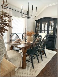 a dining room table with chairs and a china cabinet