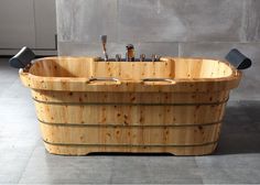 a large wooden tub with two bottles in it's center and handles on each side