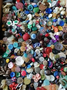 a box filled with lots of different types of buttoned buttons on top of each other