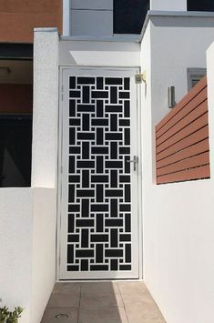 a white door with an intricate design on the side and brick wall next to it