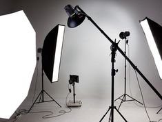 several lighting equipment are set up in front of a white background for an advertisement or photo shoot