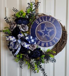 a wreath with the word cowboys on it is hanging on a white door and decorated with flowers