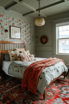 a bed sitting in a bedroom next to a window with a red rug on top of it