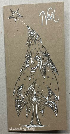 a handmade christmas card with a stylized tree and stars on the top, in brown paper