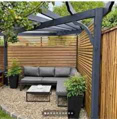 an outdoor living area with couches, tables and potted plants on the ground