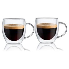 two coffee mugs sitting next to each other on a white surface with one cup filled with liquid