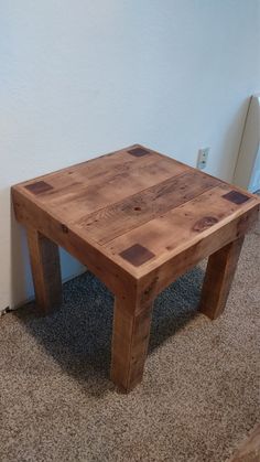 a wooden table sitting on top of a carpeted floor