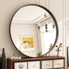 a round mirror sitting on top of a dresser