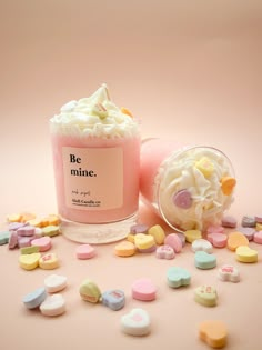 a cup filled with marshmallows sitting on top of a table next to a jar