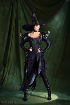 a woman dressed in black and wearing a witch costume with her hands on her hips