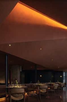 the interior of a restaurant with wooden tables and chairs, along with an orange ceiling