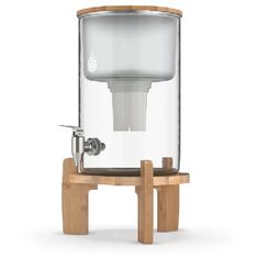 a glass water dispenser sitting on top of a wooden stand