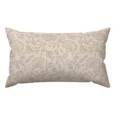 a white and beige floral pillow on a white background