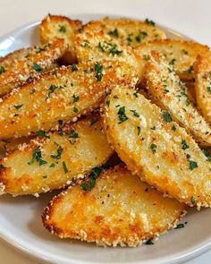 fried potatoes with parmesan cheese and seasoning on a white plate