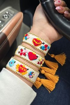 a woman is holding the steering wheel of a car with colorful beads and tassels on it