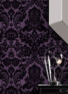 a purple and black wallpaper with an ornate design on the sideboard in front of it