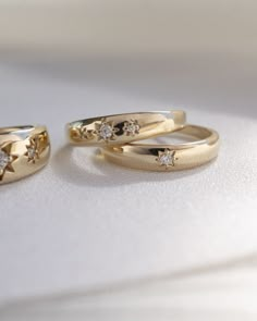 two gold wedding rings with diamonds on them