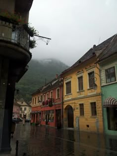 a rainy day in the town with buildings and umbrellas on an overcast day