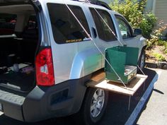 the back end of a silver van is loaded with items