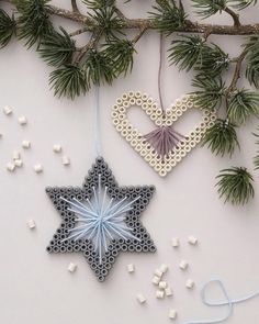 an ornament hanging from a tree branch next to other ornaments on the table