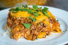 a close up of a plate of food with cheese and ground beef on it's side