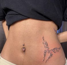 a woman's stomach with a small tattoo on the side and a tiny flower at the bottom