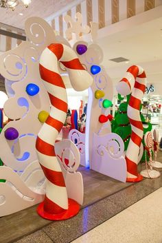 large candy canes and christmas decorations on display in a shopping mall or department store