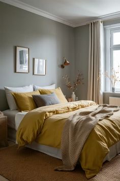 a bed with yellow comforter and pillows in a bedroom next to a large window