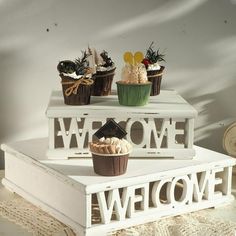 there are cupcakes on top of the welcome sign