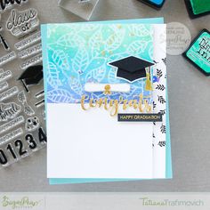 a graduation card with stamps and stamping on the table next to some other items