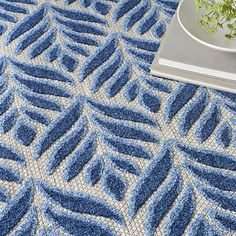 From the living room to the patio, this Aloha Blue Botanical Indoor/Outdoor Rug will put a tropical charm on any space. Its refreshing texture and style is perfect for summer! Rug measures 6 ft. in length x 9 ft. in height Crafted of polypropylene with latex backing Machine-made construction Botanical leaf pattern Hues of blue and tan Flat weave with raised, cut patterns Stain resistant Rug pad not included Safe for outdoor use Care: Vacuum regularly with no beater bar. Rinse with a hose and air dry. To extend life, bring indoors during extreme weather. This item is available at Kirklands.com only, not available in stores. Please note: this item cannot be shipped to APO/FPO addresses. | Aloha Blue Botanical Indoor/Outdoor Rug, 6x9, Blue, 6x9 , Polypropylene | Kirkland's Home Tropical Area Rugs, Blue Outdoor Rug, Botanical Rug, Palm Leaf Pattern, Aloha Collection, Dining Room And Living Room, Nourison Rugs, Palm Leaves Pattern, Patio Balcony