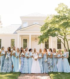 a group of bridesmaids standing in front of a white house