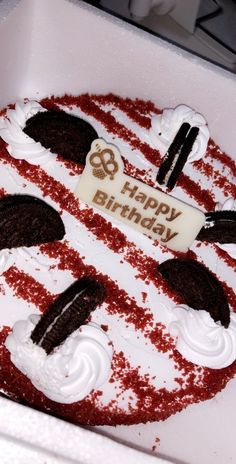 a birthday cake with white frosting and red sprinkles in a box