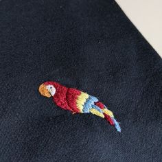 a colorful parrot embroidered on the back of a sweater