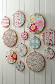 the wall is decorated with different types of embroiderys and flowers on fabric hoop holders