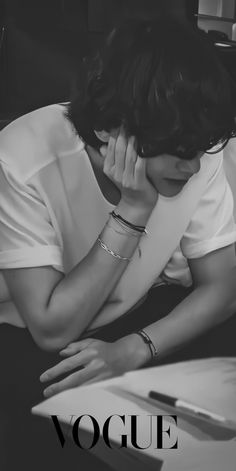 black and white photograph of a woman with her hand on her face while sitting down