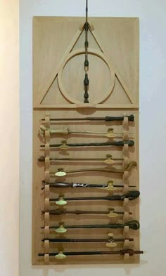 a wooden wall hanging with many different types of tools on it's sides and an arrow in the middle