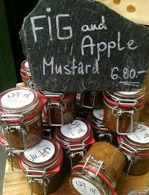 several jars filled with food sitting on top of a wooden table next to a sign