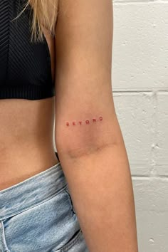 a woman's arm with the word beyond written in red ink on her left side