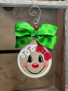 a christmas ornament hanging from a door with a green bow and polka dots