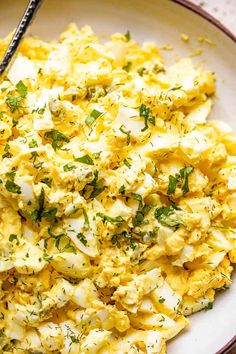 a bowl filled with scrambled eggs and garnished with parsley on the side