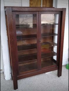 an old wooden bookcase with glass doors