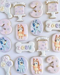 decorated cookies are arranged in the shape of numbers and dog figures on a white surface