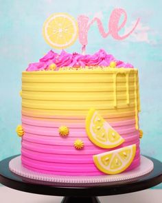 a pink and yellow cake sitting on top of a table