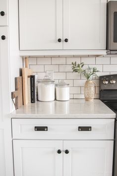 a kitchen with white cabinets and black appliances