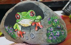 a painted rock with a frog on it