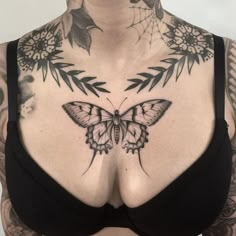 a woman with tattoos on her chest has a butterfly tattoo on her left side breast