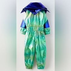 a green and blue snowsuit hanging up on a hanger in front of a white wall