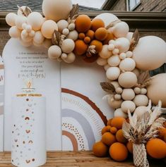 an arch made out of balloons and other decorations on a wooden floor next to a building